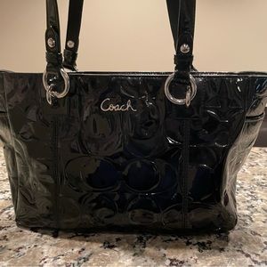 Black patent leather Coach purse with embossed “c” logo